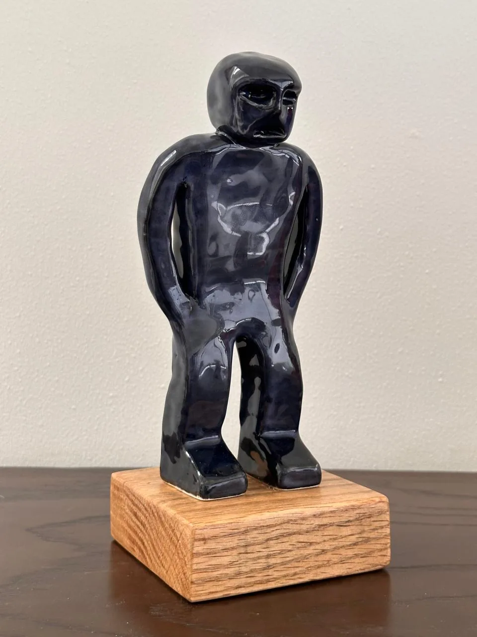 U-Mano 02, figura azul de cuerpo completo sobre una base de madera.
